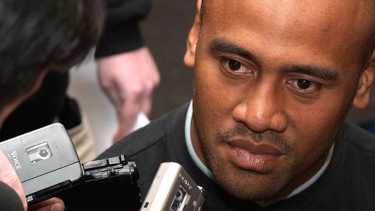 Close portrait of Jonah Lomu surrounded by press microphones