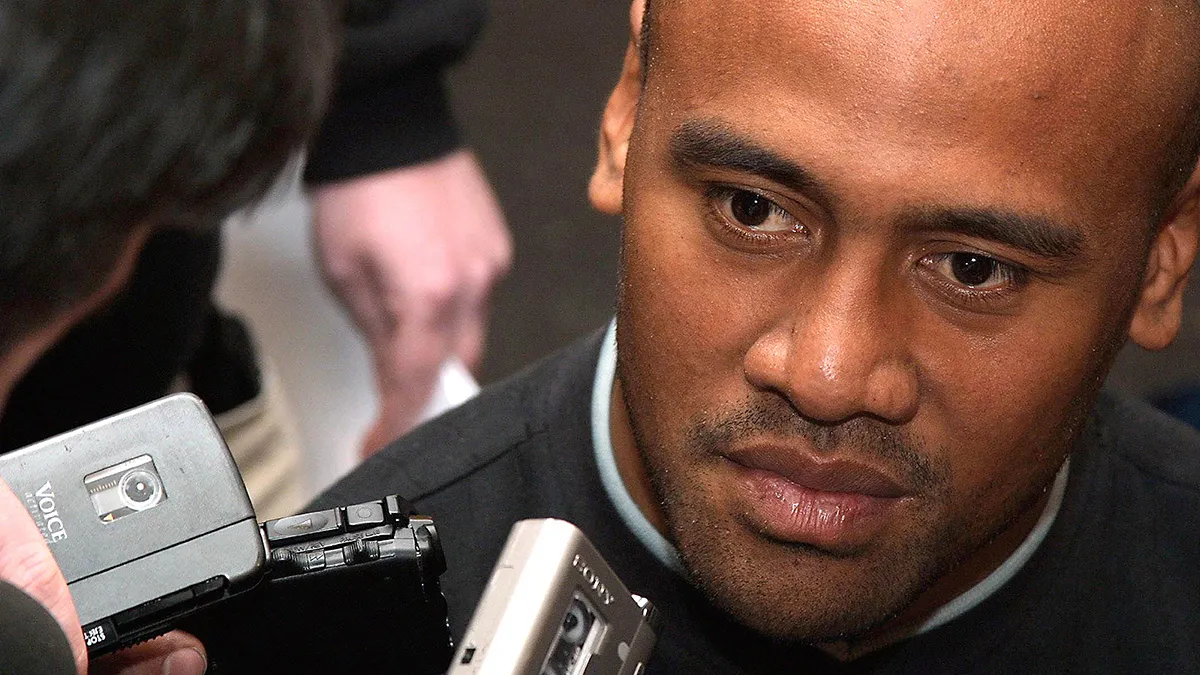 Jonah Lomu surrounded by press microphones