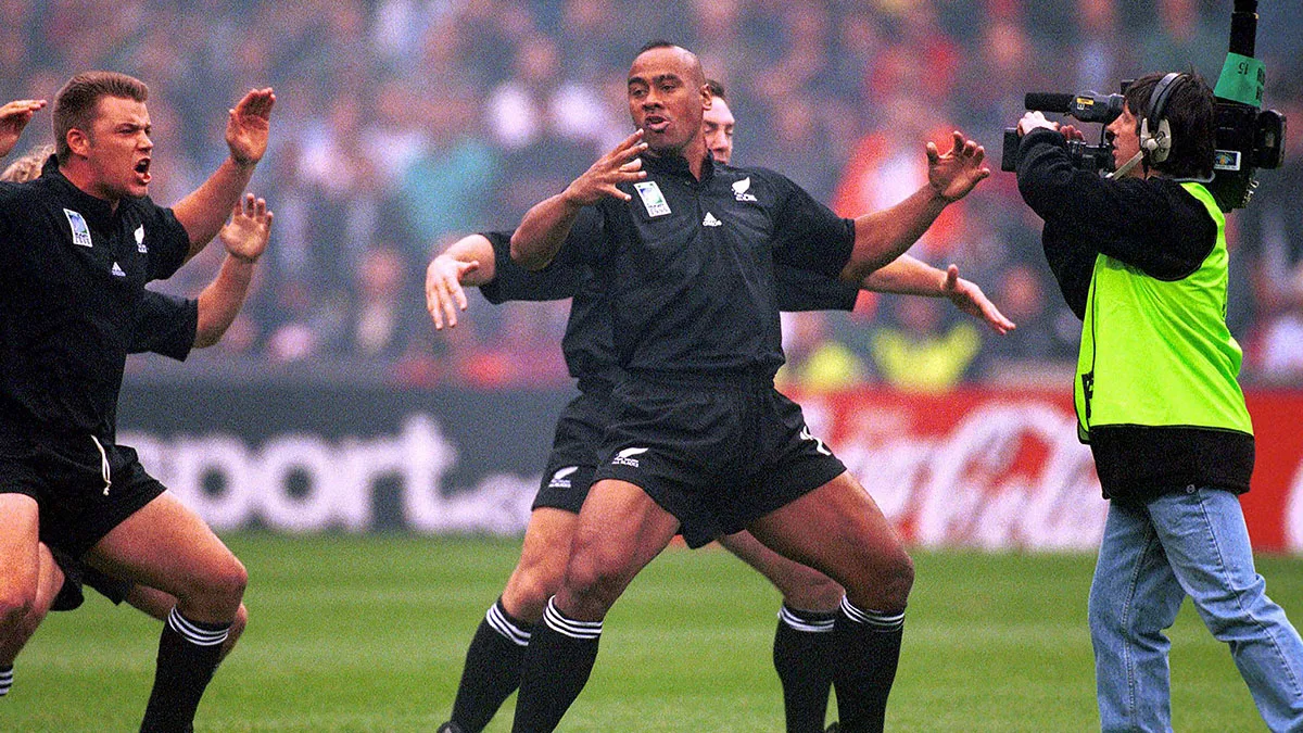 Jonah Lomu performing the haka beside teammates as a television camera films